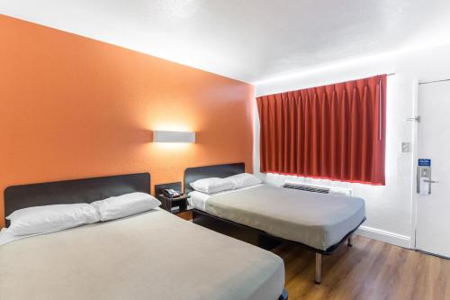 una camera d'albergo con due letti e una finestra rossa di Motel 6 - Pensacola West a Pensacola