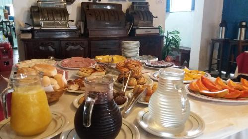 een tafel met borden met eten en drinken bij Pousada Santa Rita in Paraty