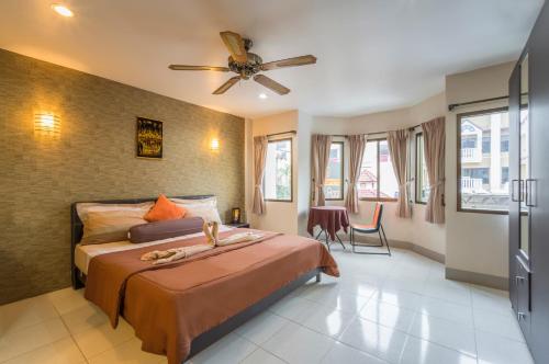 a bedroom with a bed and a ceiling fan at Living Room Guesthouse & Cafe Bar in Karon Beach