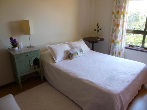 a bedroom with a white bed and a window at Porto's City Park & Surf Beach Rooms in Matosinhos