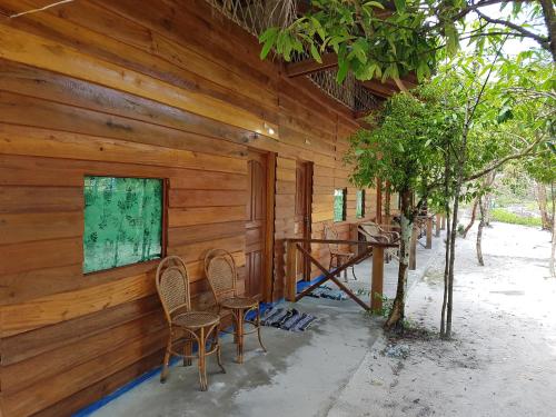 a wooden house with two chairs and a porch at Sweet Time Bungalows in Koh Rong Sanloem