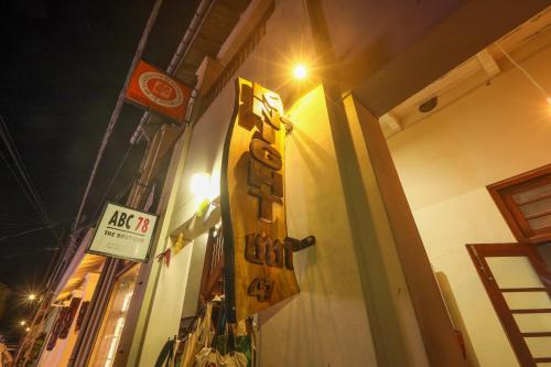 a sign on the side of a building at night at Knight Inn - Galle Fort in Galle