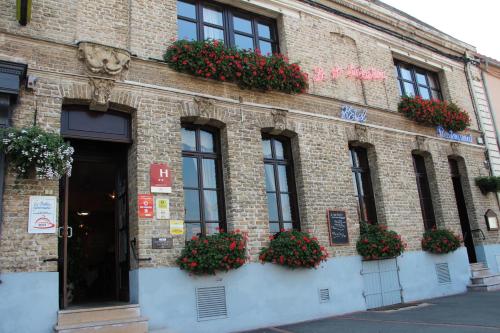a brick building with flower boxes on the side of it at Le Saint Sébastien in Blendecques