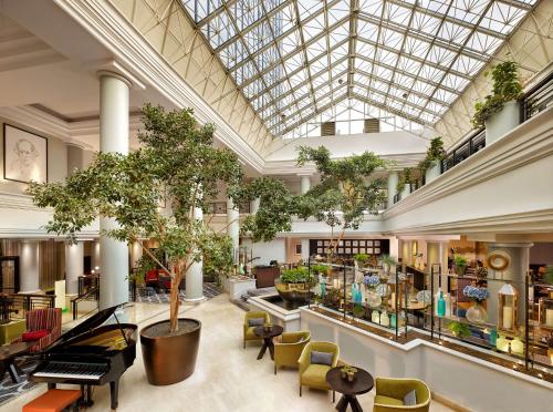 un gran vestíbulo con mesas, sillas y árboles en Hyatt Regency Birmingham en Birmingham