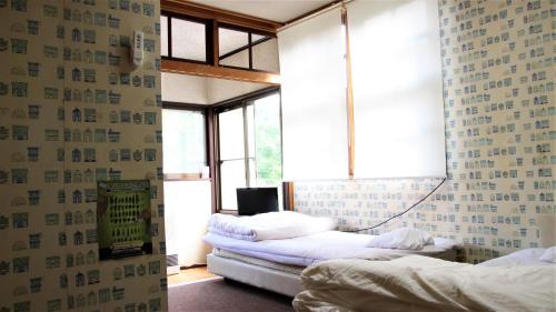 a bedroom with two beds in a room with a mirror at Lodge Oakland in Shinano