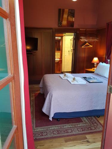a bedroom with a bed and a door leading into a room at Bridgefield Guest House in Margaret River Town