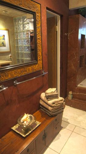a bathroom with a counter with a mirror and a sink at Artistic Resort Like Home with Pool in Fullerton