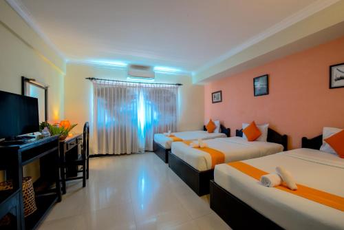 a hotel room with two beds and a flat screen tv at Angkor Panoramic Boutique Hotel in Siem Reap