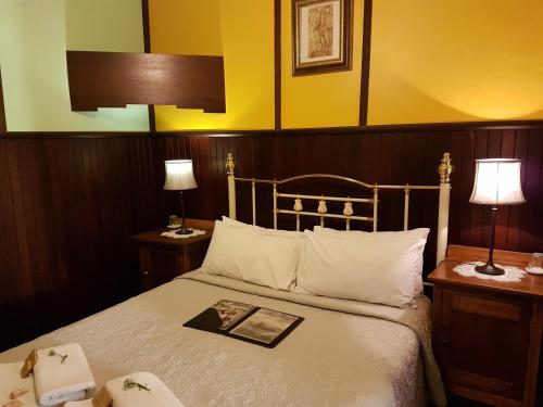 a bedroom with a bed with a book on it at Bridgefield Guest House in Margaret River Town