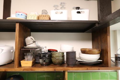 a shelf with bowls and other dishes on it at GUEST HOUSE E-NINE in Kyoto