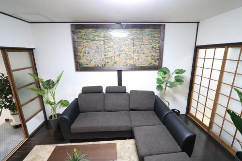 a living room with a couch and some plants at GUEST HOUSE E-NINE in Kyoto