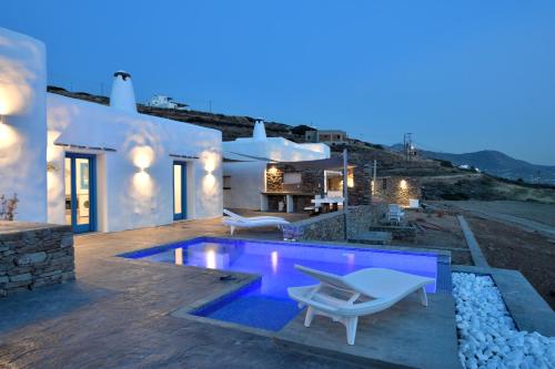 a villa with a swimming pool at night at Magic Krios in Parikia