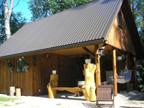 a large wooden cabin with a metal roof at Lonni Nature Eco-Accommodation in Hagudi