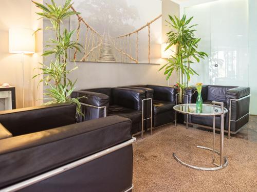 a waiting room with black leather couches and a table at Hotel Berlin Mitte by Campanile in Berlin