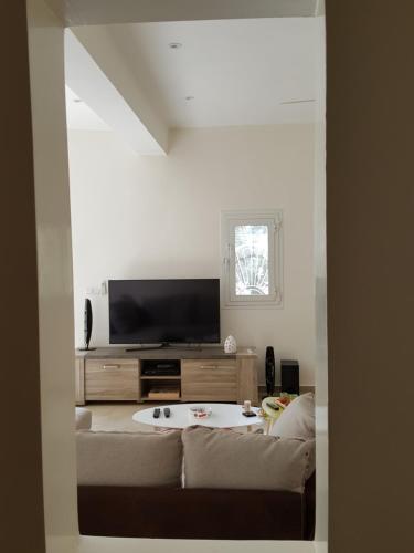 a living room with a couch and a flat screen tv at Villa Du Soleil Ngaparou in Ngaparou