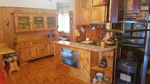 a kitchen with wooden cabinets and a counter top at Fiocco di Neve in Massa dʼAlbe