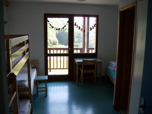 a bedroom with a window and a table and a desk at Gîte Le Shantoné in Saint-Michel-de-Maurienne