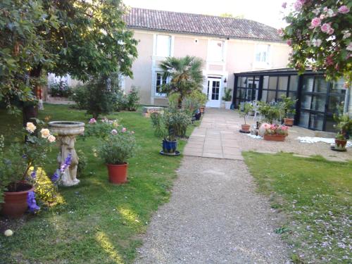 a garden with potted plants and a house at la Rosaliere in Chabournay
