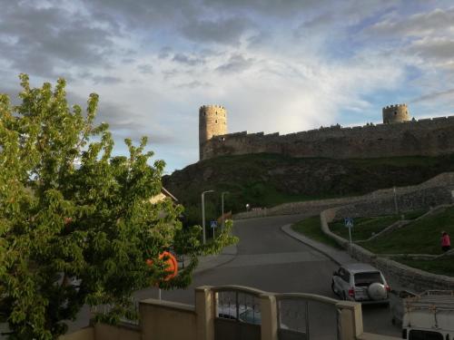 a car parked on a road with a castle in the background at Light House Old City in Akhaltsikhe