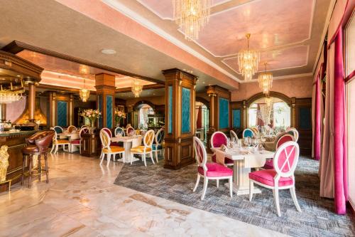 a dining room with tables and chairs and chandeliers at Spa Hotel Rich in Velingrad