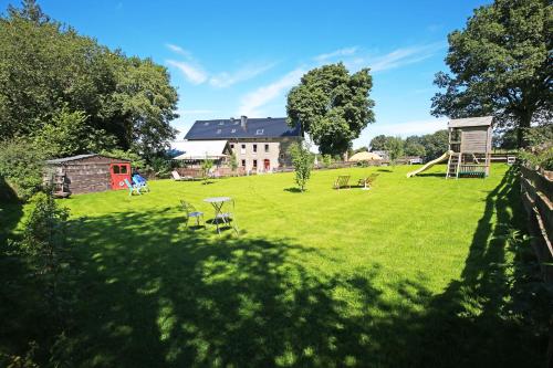 a large grassy yard with a house and a playground at Holiday Home Weisten 5 in Burg-Reuland