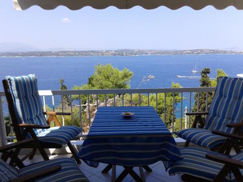 a table and chairs on a balcony with a view of the water at iliana's seaside maisonette in Spetses