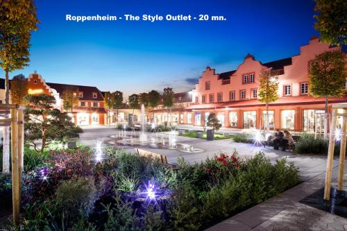 a town square at night with a fountain at L'ARBOGAST in Herrlisheim