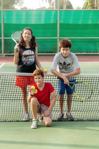 a group of young people standing on a tennis court at Anantara Vacation Club Mai Khao Phuket in Mai Khao Beach