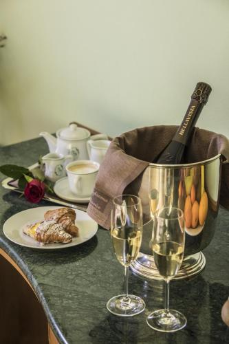 a table with a plate of food and wine glasses at La Fonte Hotel in Ome