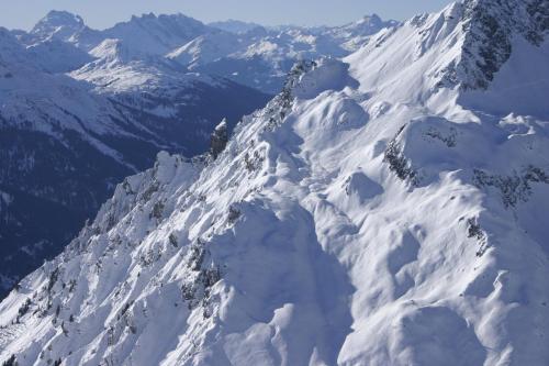 a mountain covered in snow with mountains in the background at Arlberg Lodges in Stuben am Arlberg