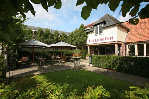 a restaurant with a lawn in front of a building at The Lion Inn in Chelmsford