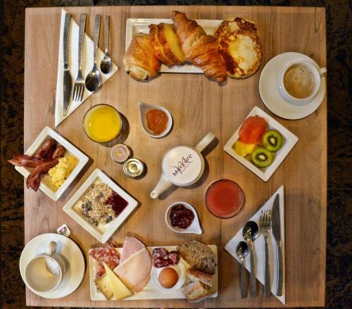 a wooden table with breakfast foods on it at Mercure Toulouse Centre Wilson Capitole in Toulouse