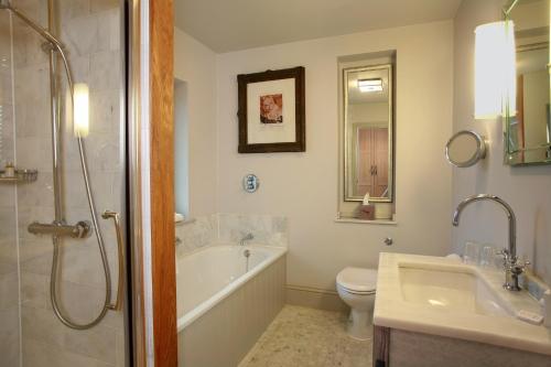 a bathroom with a tub and a toilet and a sink at The Lion Inn in Chelmsford