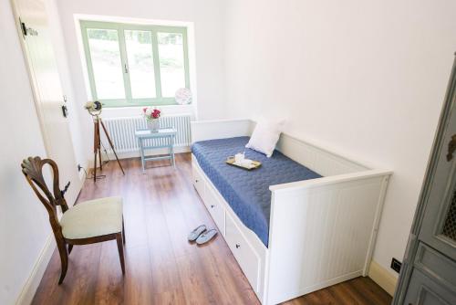 łóżko w pokoju z oknem i krzesłem w obiekcie Maison BOGArT w mieście Alsobogát