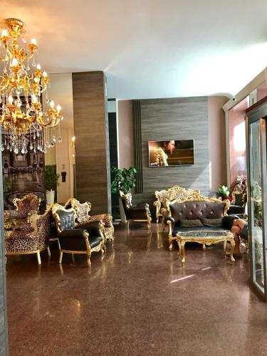 a living room with couches and a chandelier at Canova Hotel in Milan