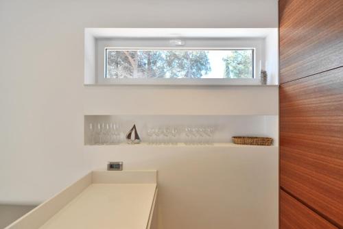 a room with a window and a shelf with wine glasses at Chiponsky One - 5 star beachfront property in Bol