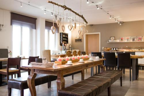 Hotel Restaurant Am Kellhof في سينجين: غرفة طعام مع طاولة وكراسي خشبية