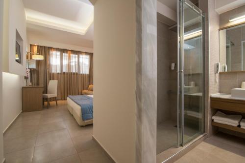 ein Hotelzimmer mit einem Schlafzimmer und einem Bad in der Unterkunft Cosmopolitan Hotel & Spa in Paralia Katerinis