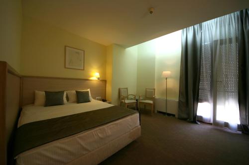 A bed or beds in a room at Savoy Hotel