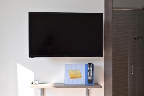 a flat screen tv on a wall with a remote control at Lvresidence Roccelletta in Catanzaro Lido