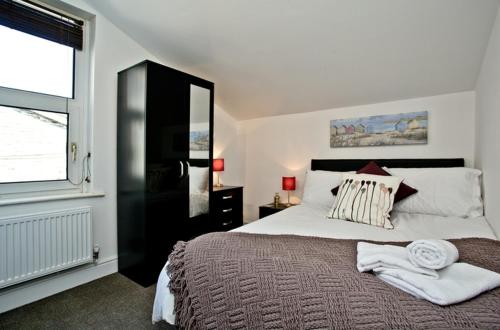 sypialnia z dużym łóżkiem i oknem w obiekcie Sea-Esta w mieście Weymouth