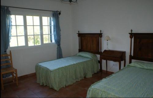 サント・トマスにあるVilla Macarena menorcaのベッド2台と窓が備わるホテルルームです。