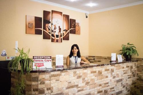 a woman is standing in front of a counter at Hotel Sluch in Starokostyantyniv