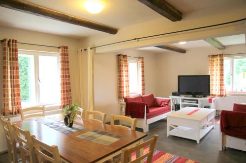 a living room with a table and a television at Karu Holiday Home in Laiusevälja