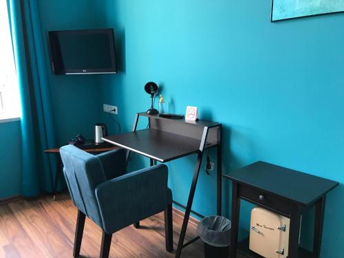 a desk and chair in a room with a blue wall at SmartHotel Mystique Self check-in in Bad Homburg vor der Höhe