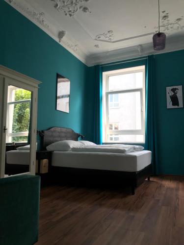 a bedroom with a bed and a blue wall at SmartHotel Mystique Self check-in in Bad Homburg vor der Höhe
