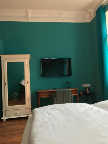 a bedroom with a bed and a tv on the wall at SmartHotel Mystique Self check-in in Bad Homburg vor der Höhe