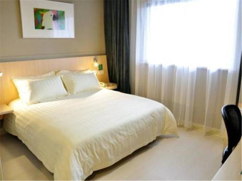 a bedroom with a white bed and a window at Jinjiang Inn Qingdao Cangkou Park in Qingdao