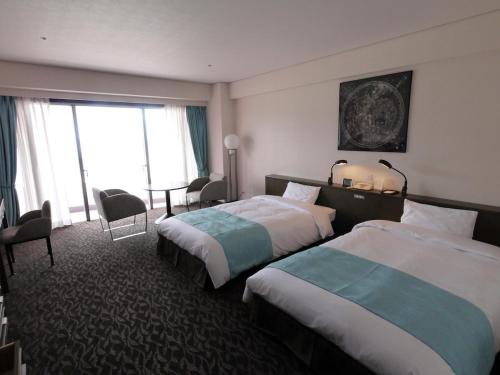 pokój hotelowy z 2 łóżkami i oknem w obiekcie Tanegashima Iwasaki Hotel w Minamitane