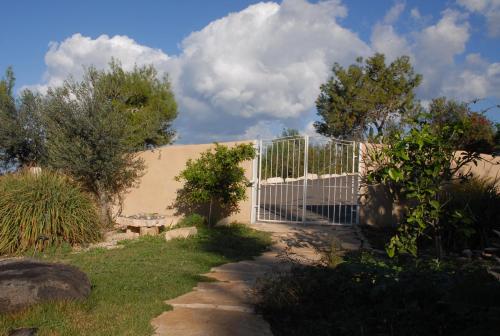 a white fence in front of a building at Above the Sea in ‘En Hod